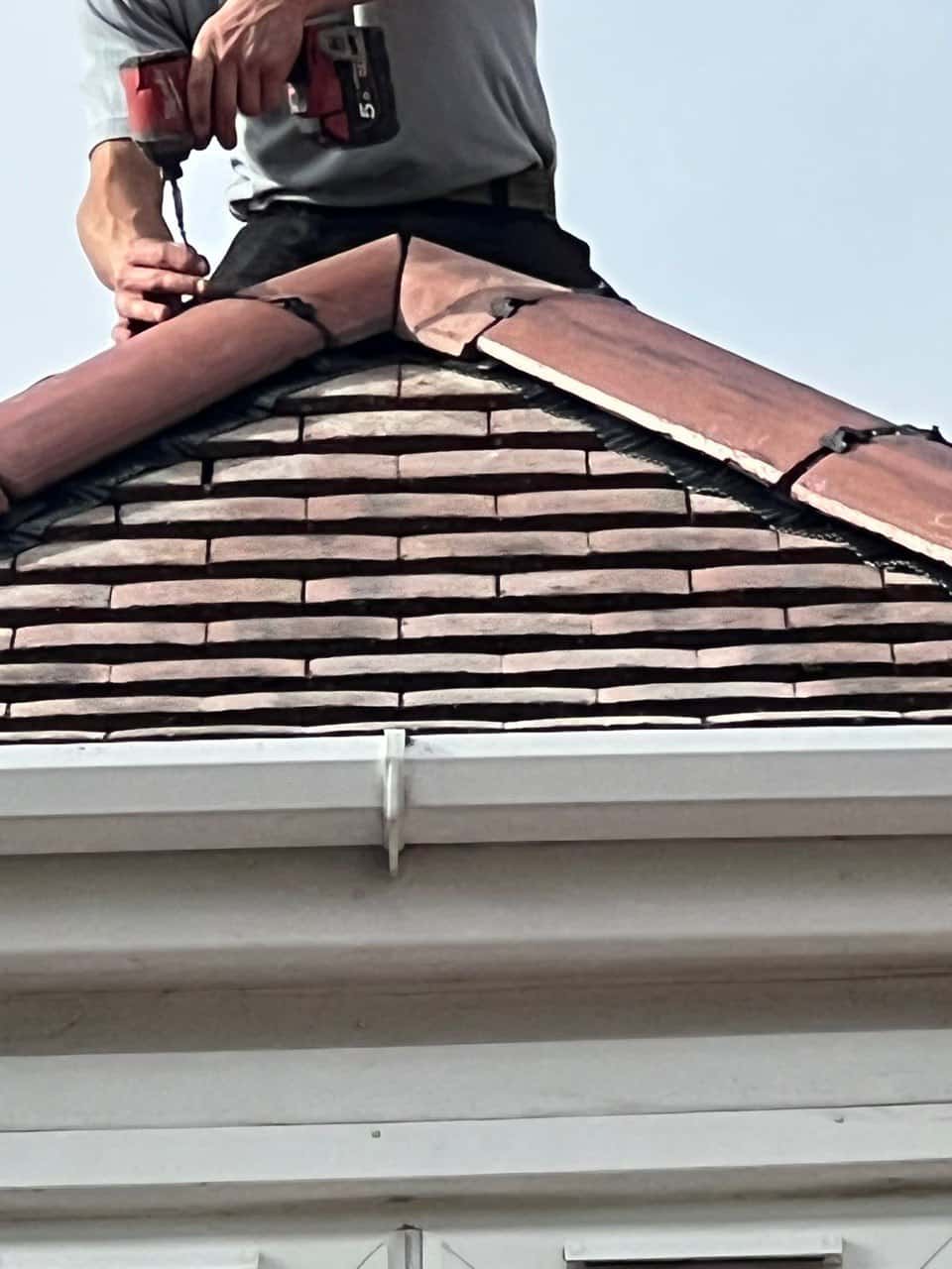 This is a photo of one of the operatives of Southsea Roofing Repairs installing new ridge tiles