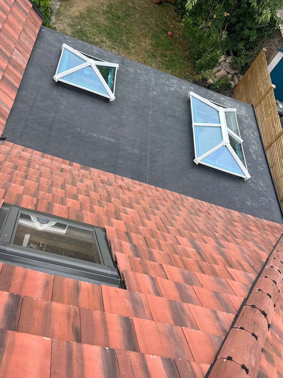 This is a photo taken from the roof ridge looking down a tiled pitched roof on to a flat roof. Works carried out by Southsea Roofing Repairs